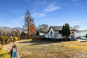 View of property exterior featuring a mountain view and a yard