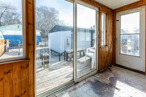 Doorway to outside featuring wooden walls