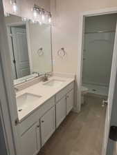 Bathroom with a shower, vanity, tile patterned floors, and toilet