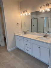 Bathroom with tile patterned flooring, vanity, toilet, and a shower with door