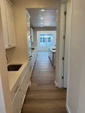 Corridor featuring sink, dark wood-type flooring, and a textured ceiling