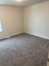 Carpeted spare room featuring a textured ceiling