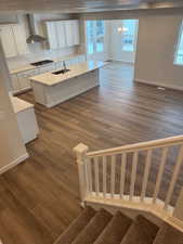 Stairway with a textured ceiling, wood-type flooring, sink, and a chandelier