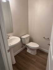 Bathroom featuring hardwood / wood-style floors, toilet, and sink