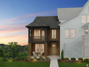 View of front of house featuring a yard and a covered balcony and covered porch