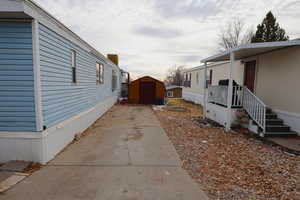 View of side of property with a storage shed