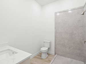 Bathroom with hardwood / wood-style floors, vanity, and toilet