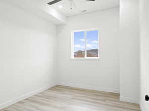 Spare room featuring ceiling fan and light wood-type flooring