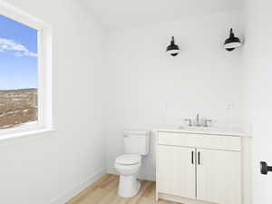 Bathroom with wood-type flooring, vanity, and toilet