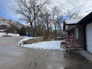 Snowy yard with a mountain view and a garage