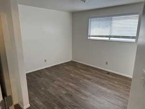 Unfurnished room with dark hardwood / wood-style flooring