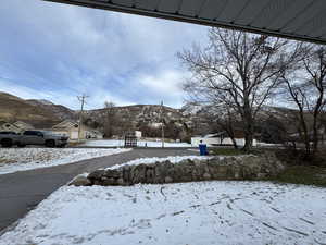 Yard layered in snow featuring a mountain view