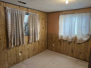 Spare room with carpet floors and wooden walls