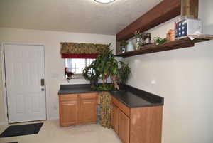 Kitchen with beam ceiling and a textured ceiling