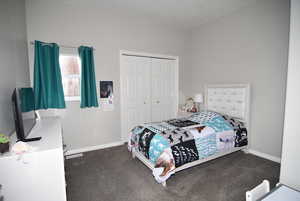 Bedroom featuring dark carpet and a closet