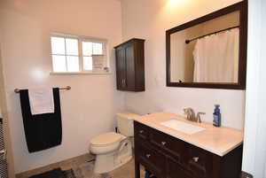 Bathroom with a shower with curtain, tile patterned flooring, vanity, and toilet