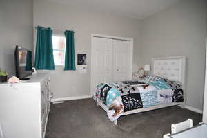 Bedroom featuring dark carpet and a closet