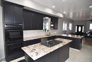 Kitchen with sink, tasteful backsplash, kitchen peninsula, a kitchen island, and appliances with stainless steel finishes