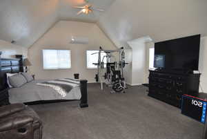 Carpeted bedroom with a wall unit AC, ceiling fan, and lofted ceiling