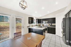 Kitchen with pendant lighting, lofted ceiling, sink, decorative backsplash, and stainless steel appliances