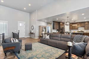 Living room featuring a towering ceiling and light hardwood / wood-style floors