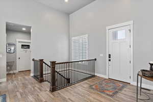 Foyer with a high ceiling and light hardwood / wood-style flooring