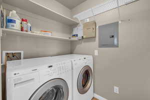 Laundry room featuring electric panel and separate washer and dryer