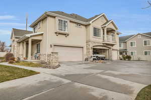 View of front of property with a balcony and a garage