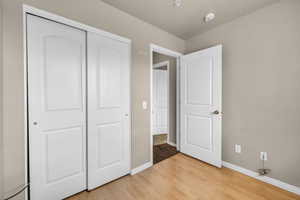 Unfurnished bedroom with light wood-type flooring and a closet