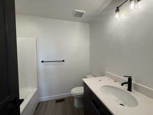 Full bathroom featuring vanity, hardwood / wood-style flooring, separate shower and tub, toilet, and a textured ceiling