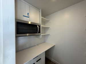 Interior space featuring light stone countertops, light brown cabinets, backsplash, and dark wood-type flooring