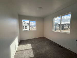 Carpeted spare room with a textured ceiling