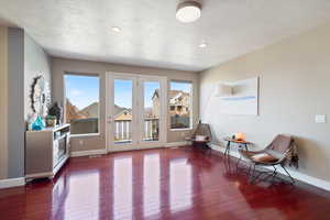 Sitting room featuring a textured ceiling, wood finished floors, and baseboards