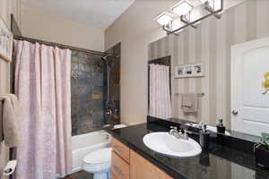 Full bath featuring shower / tub combo with curtain, vanity, and toilet