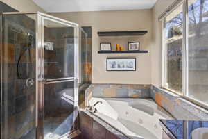 Bathroom featuring a whirlpool tub and a stall shower