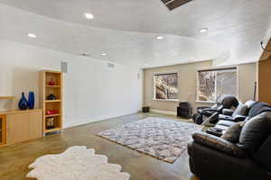 Living area with baseboards, concrete floors, visible vents, and recessed lighting