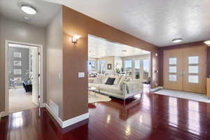 Interior space featuring hardwood / wood-style flooring, baseboards, visible vents, and french doors