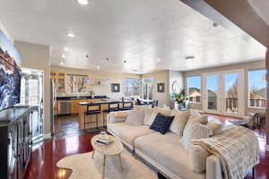 Living area featuring a wealth of natural light, dark wood finished floors, a textured ceiling, and recessed lighting