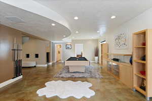 Recreation room featuring concrete flooring, a textured ceiling, visible vents, and recessed lighting