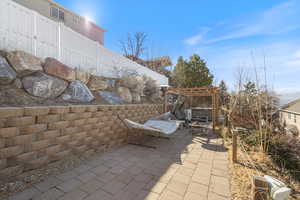 View of patio / terrace with a fire pit, fence, and a pergola