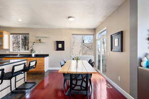 Dining room with dark wood-type flooring and baseboards