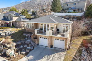 View of front of house with a mountain view, a balcony, a garage, concrete driveway, and a residential view