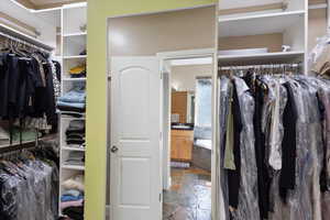 Spacious closet featuring a sink and stone tile floors