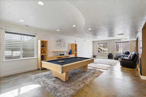 Playroom featuring recessed lighting, visible vents, a textured ceiling, concrete floors, and baseboards