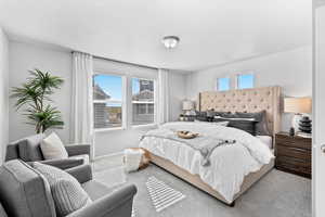 Bedroom with light colored carpet and a textured ceiling