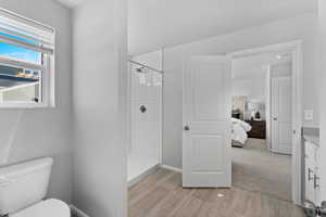 Bathroom with vanity, toilet, and tiled shower