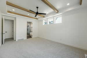 Unfurnished primary bedroom featuring carpet flooring, ceiling fan, and connected bathroom