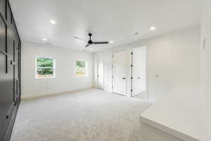 Unfurnished great room with ceiling fan, light colored carpet, and a textured ceiling