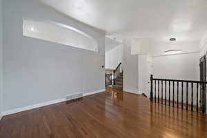 Spare room with lofted ceiling and dark hardwood / wood-style floors