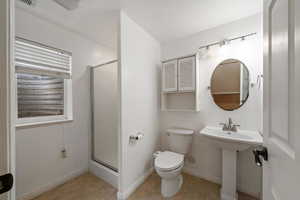 Bathroom with a textured ceiling, tile patterned flooring, an enclosed shower, and toilet